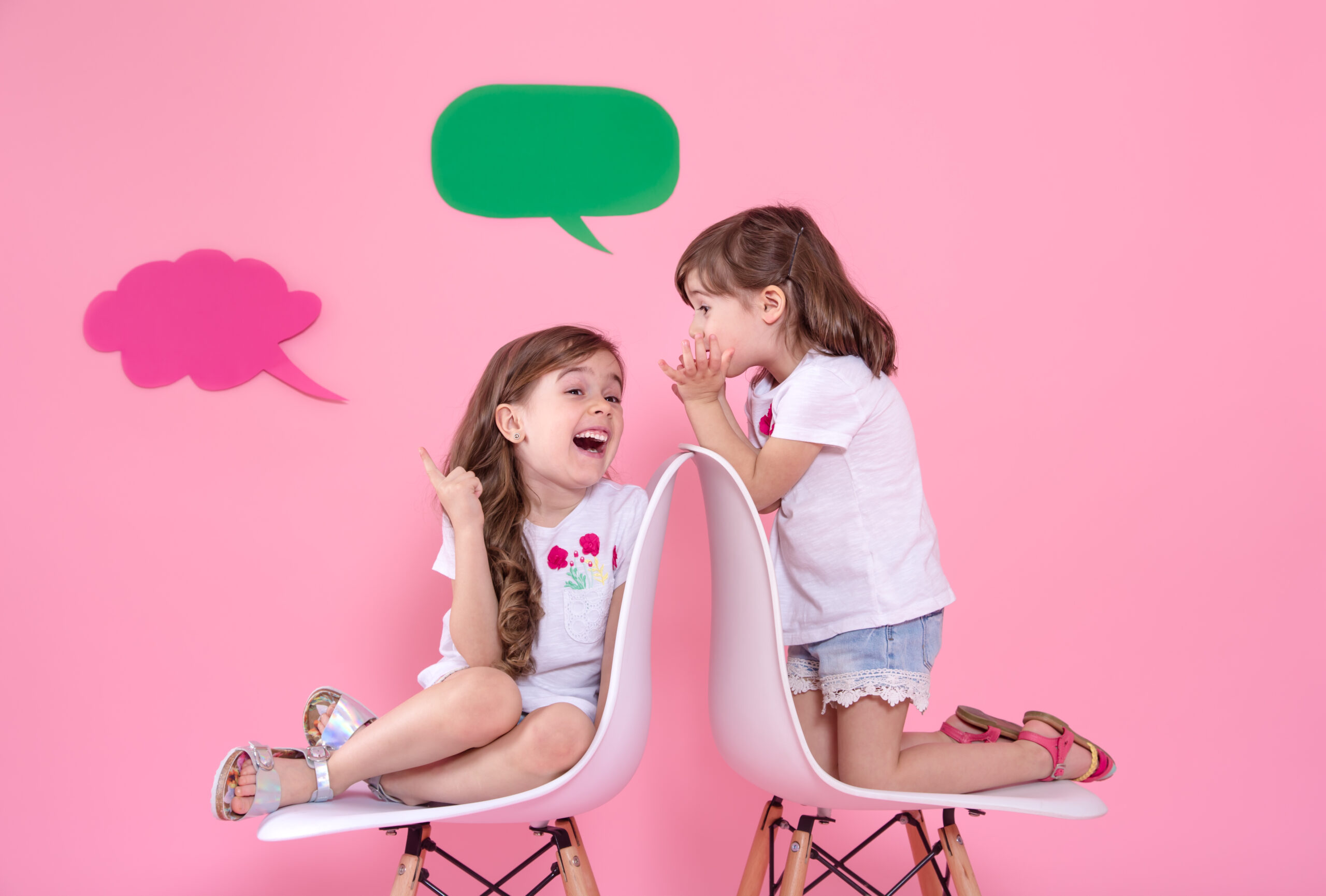two little girls colored wall with speech icons scaled
